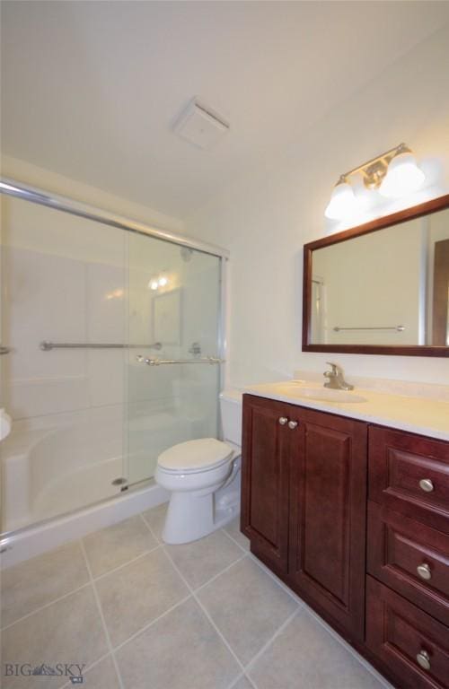 full bathroom featuring vanity, tile patterned floors, a stall shower, and toilet