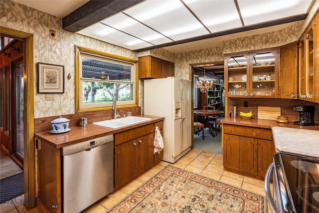423 Riverview Ct, Great Falls, MT 59404 - kitchen with white refrigerator with ice dispenser, stainless steel dishwasher, a sink, wallpapered walls, and light tile patterned flooring