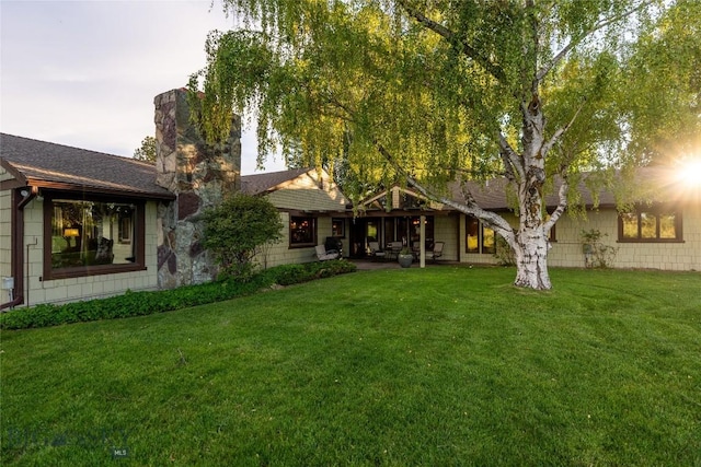 423 Riverview Ct, Great Falls, MT 59404 - back of property featuring roof with shingles, a chimney, and a yard