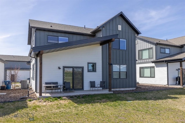 rear view of house with board and batten siding, a patio, a yard, and cooling unit