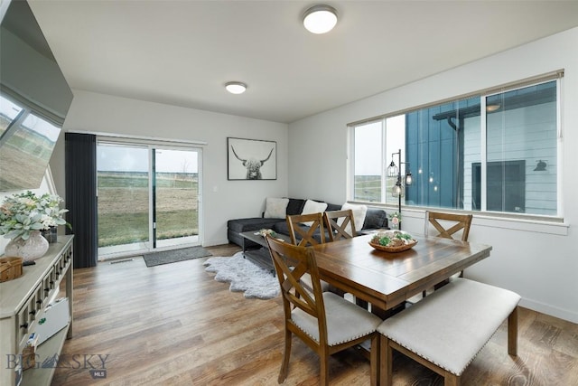 dining room with light wood-type flooring and baseboards