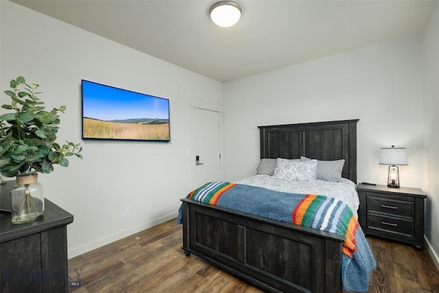 bedroom with baseboards and dark wood finished floors