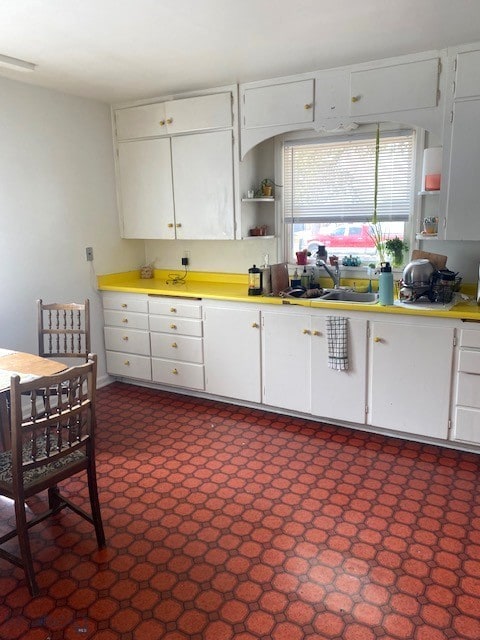 kitchen featuring a sink, white cabinetry, and light countertops