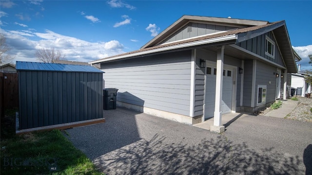 417 Henry Dr, Belgrade, MT 59714 - view of property exterior featuring board and batten siding, a storage unit, and a garage