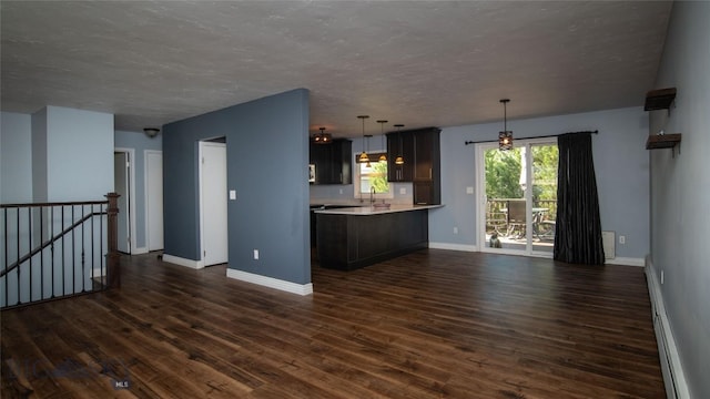 417 Henry Dr, Belgrade, MT 59714 - kitchen featuring open floor plan, light countertops, dark wood finished floors, a textured ceiling, and decorative light fixtures
