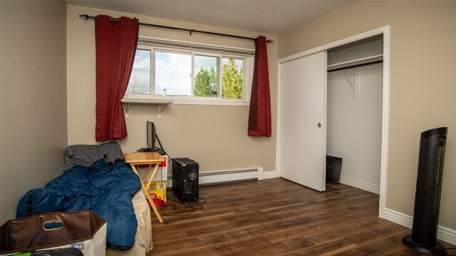 417 Henry Dr, Belgrade, MT 59714 - bedroom featuring a closet, baseboards, wood finished floors, and a baseboard radiator