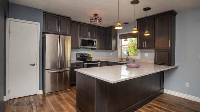417 Henry Dr, Belgrade, MT 59714 - kitchen with stainless steel appliances, a peninsula, dark wood-type flooring, and dark brown cabinetry