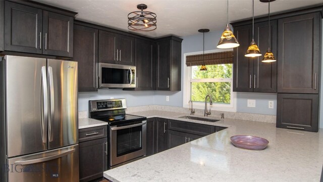 417 Henry Dr, Belgrade, MT 59714 - kitchen with stainless steel appliances, light stone countertops, pendant lighting, and a sink