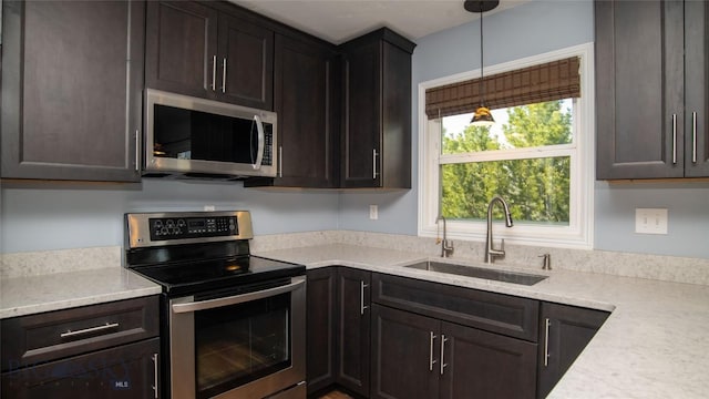 417 Henry Dr, Belgrade, MT 59714 - kitchen with decorative light fixtures, dark brown cabinetry, appliances with stainless steel finishes, and a sink