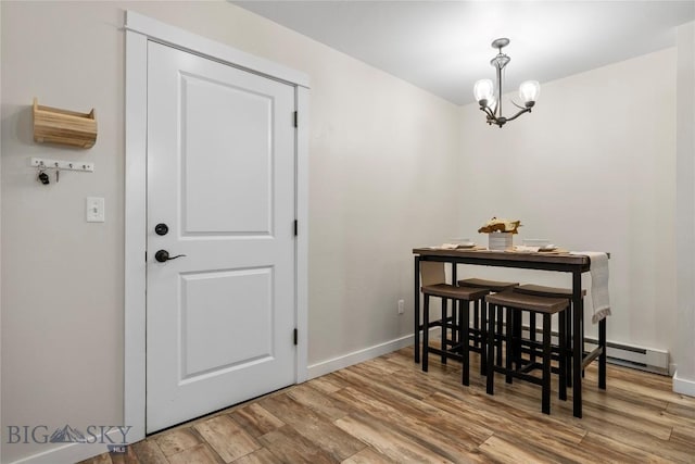 dining room featuring baseboards, wood finished floors, and a chandelier