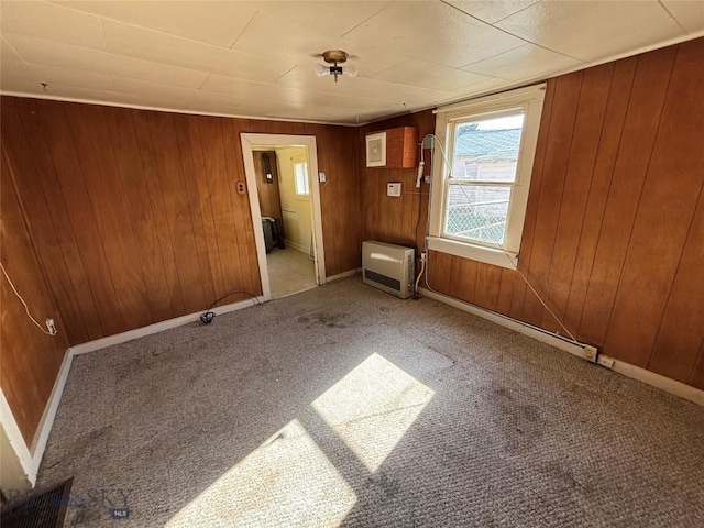 carpeted empty room with wooden walls and baseboards