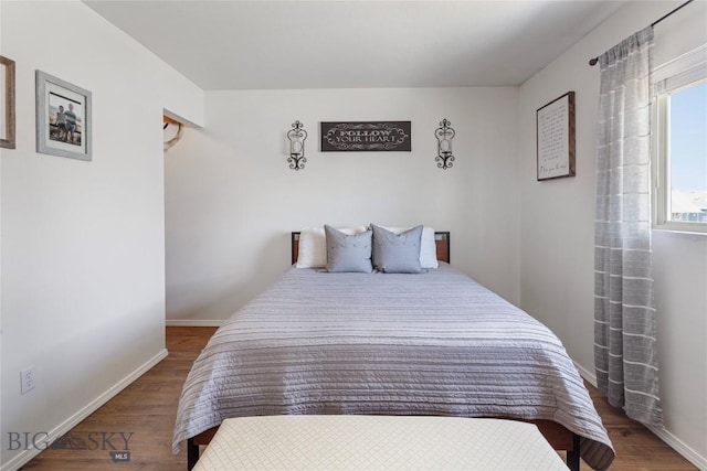 bedroom featuring baseboards and wood finished floors