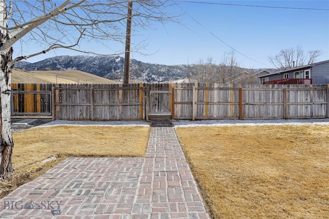view of yard with a patio area, a gate, a mountain view, and fence