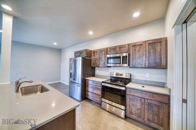 kitchen with dark brown cabinetry, recessed lighting, light countertops, a sink, and appliances with stainless steel finishes