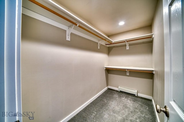 spacious closet with carpet flooring and a baseboard radiator