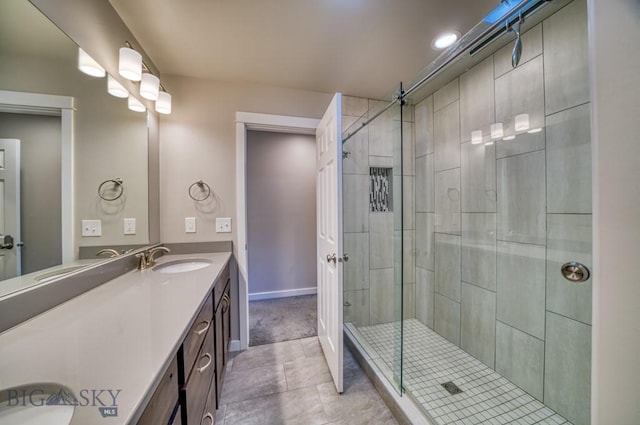 bathroom with baseboards, a shower stall, tile patterned flooring, and vanity