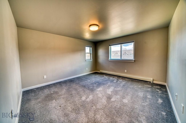 unfurnished room featuring baseboards, a baseboard heating unit, and dark carpet