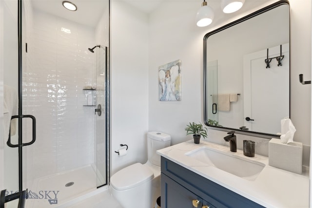 bathroom featuring vanity, a stall shower, and toilet