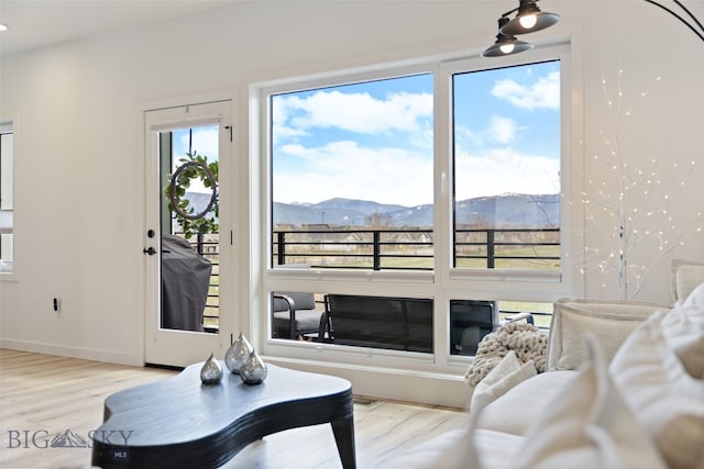 living area with baseboards, a mountain view, and wood finished floors