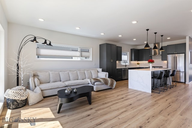 living room featuring light wood-type flooring and recessed lighting