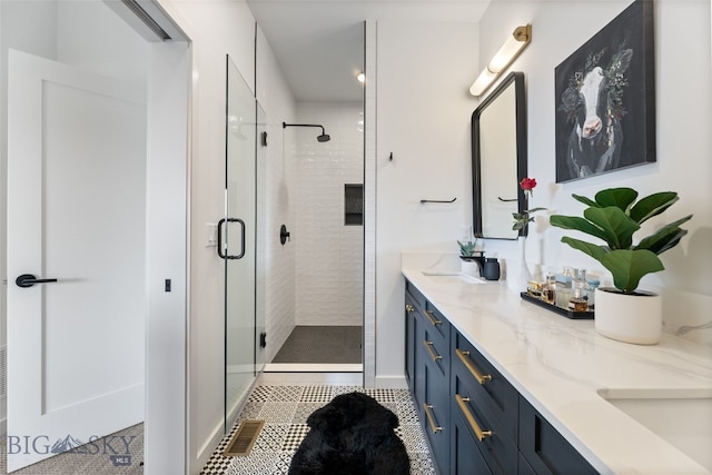 bathroom featuring a shower stall, tile patterned flooring, double vanity, and a sink