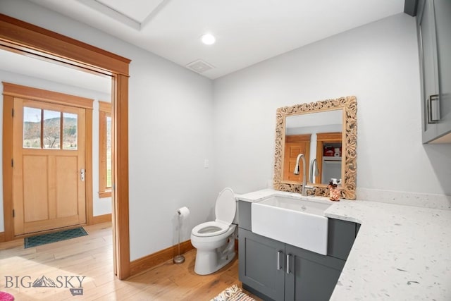 bathroom featuring vanity, toilet, recessed lighting, baseboards, and wood finished floors
