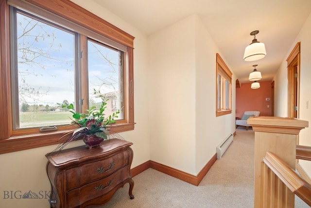 hallway with baseboards, light colored carpet, and baseboard heating