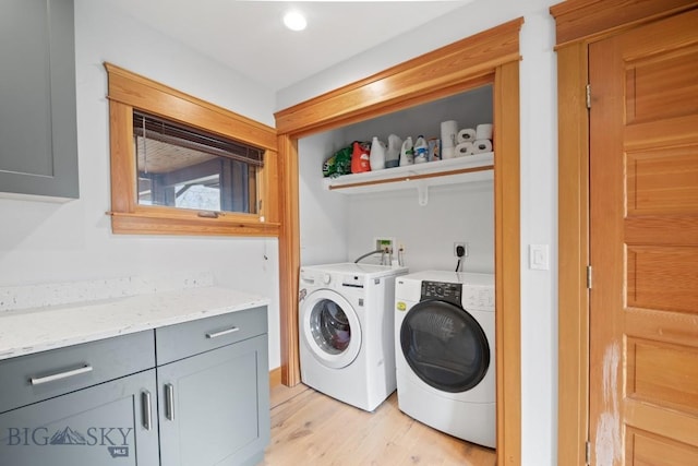 washroom with washing machine and clothes dryer, laundry area, and light wood-type flooring