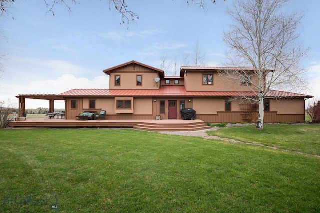 back of house featuring a lawn, a wooden deck, stucco siding, and metal roof