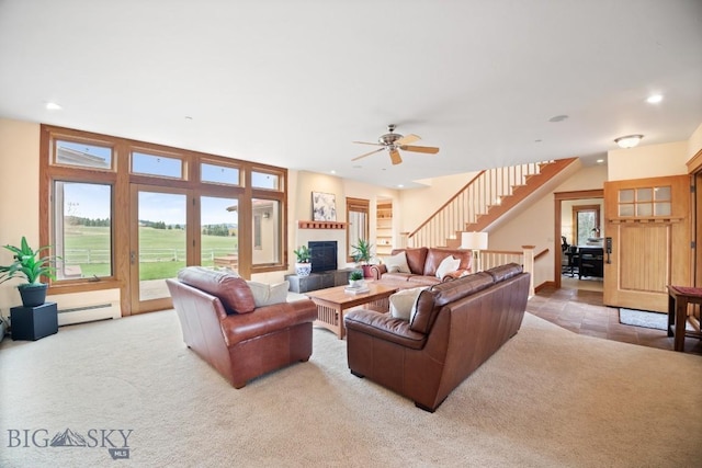 carpeted living room featuring a fireplace, a baseboard radiator, stairway, recessed lighting, and a ceiling fan