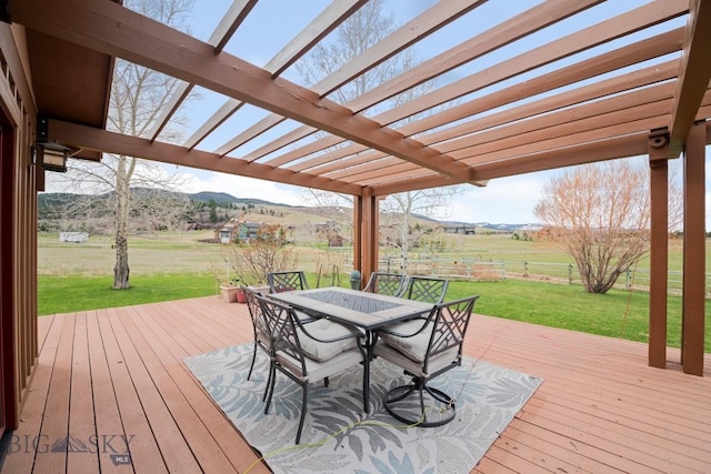 wooden terrace featuring a pergola, outdoor dining area, a rural view, a mountain view, and a yard