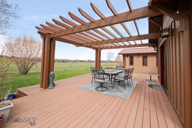 wooden terrace featuring a lawn, fence, a pergola, a rural view, and outdoor dining space