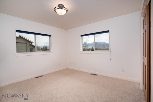 carpeted empty room with visible vents and baseboards