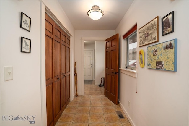 hall featuring visible vents and baseboards