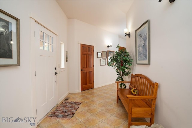 foyer entrance featuring light tile patterned floors and baseboards