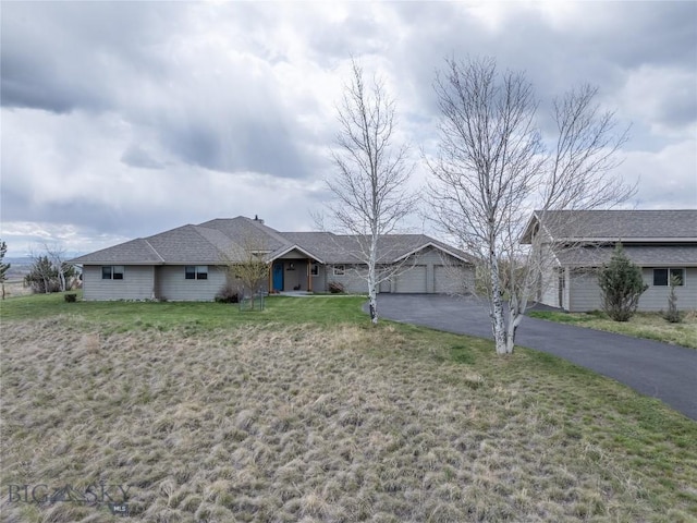 ranch-style home with an attached garage, driveway, and a front yard