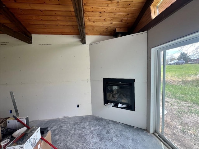 unfurnished living room featuring concrete floors, a glass covered fireplace, wooden ceiling, and beam ceiling