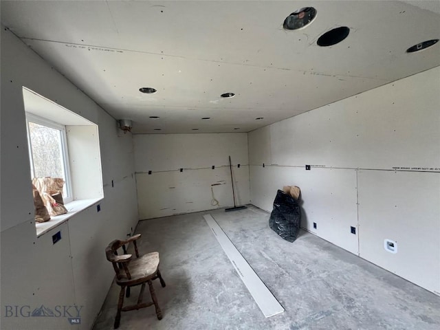 unfurnished room with unfinished concrete flooring