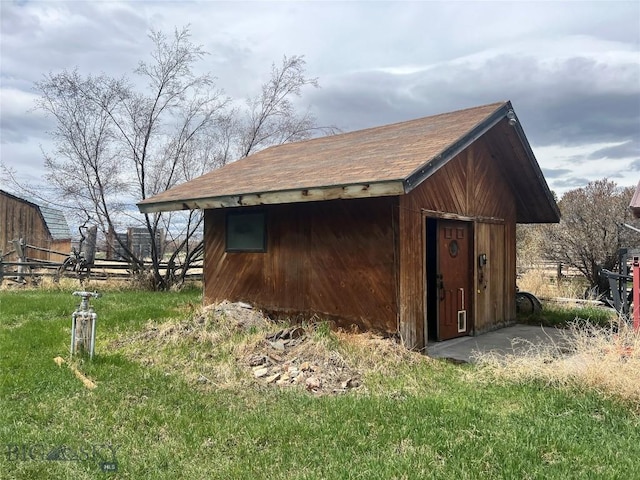 view of outbuilding featuring fence and an outdoor structure