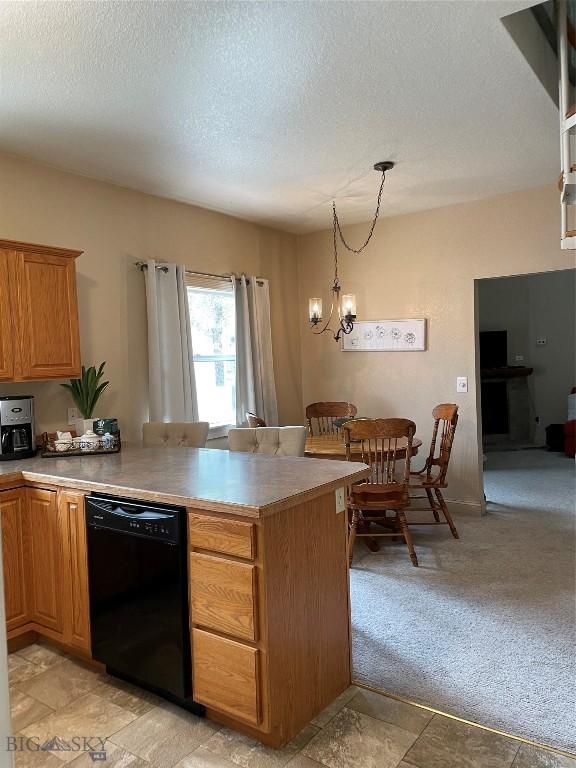 93 8th St Unit B, Belgrade, MT 59714 - kitchen featuring a textured ceiling, a peninsula, dishwasher, and light carpet