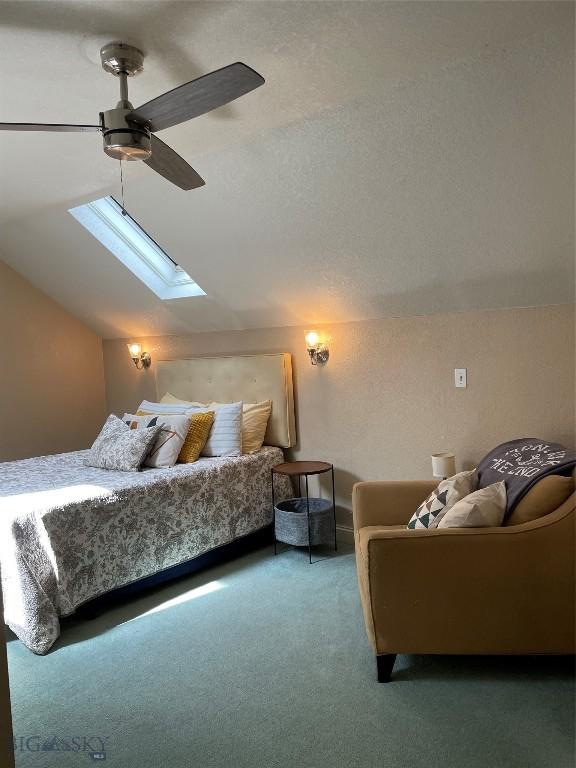 93 8th St Unit B, Belgrade, MT 59714 - carpeted bedroom with a ceiling fan and lofted ceiling with skylight