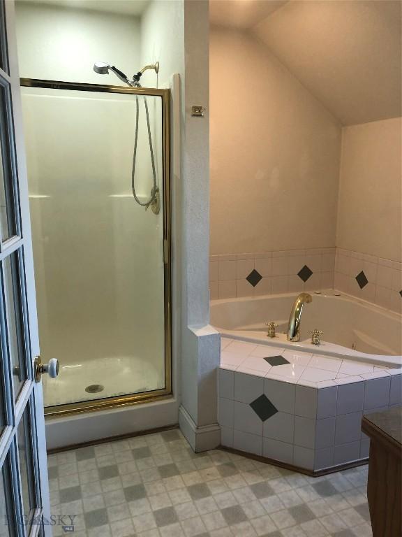 93 8th St Unit B, Belgrade, MT 59714 - full bathroom with tile patterned floors, a bath, and a stall shower