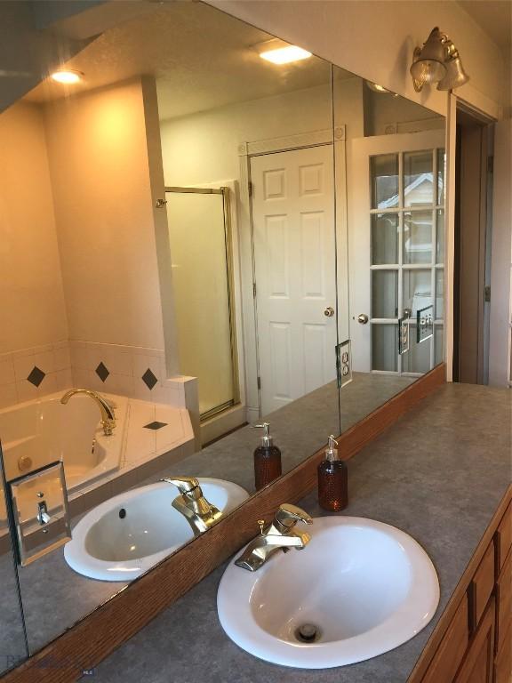 93 8th St Unit B, Belgrade, MT 59714 - full bathroom with vanity, a stall shower, and a tub with jets