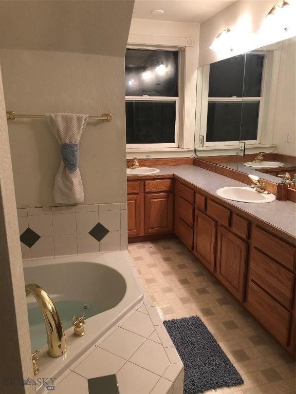93 8th St Unit B, Belgrade, MT 59714 - bathroom featuring double vanity, a sink, and a bath