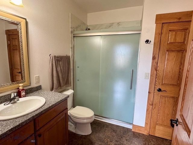 bathroom with toilet, a shower stall, and vanity