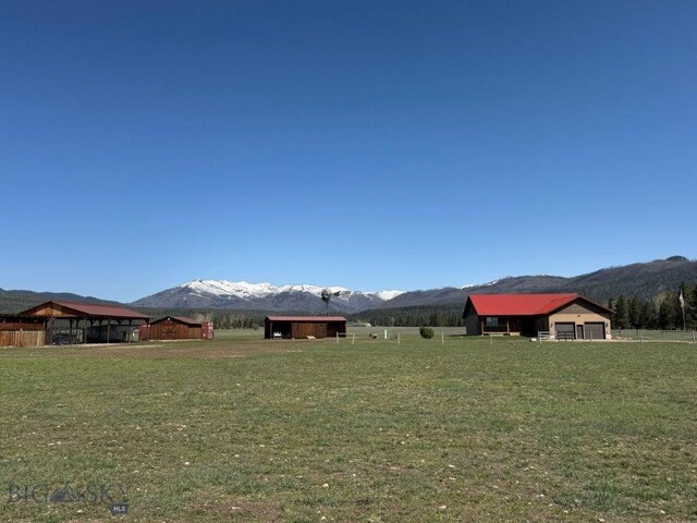 7510 Woodworth Rd, Ovando, MT 59854 - view of grassy yard with a mountain view, an outbuilding, and a garage