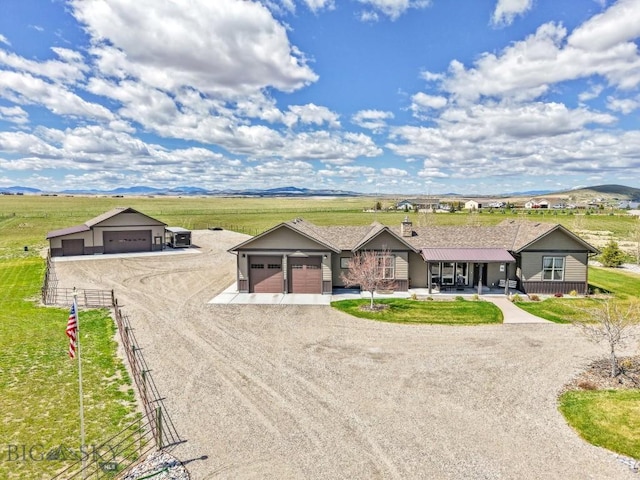 ranch-style house with fence, dirt driveway, a rural view, an attached garage, and a mountain view