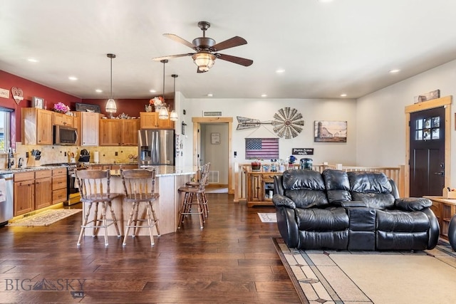 living area with dark wood-style flooring, a ceiling fan, recessed lighting, and visible vents