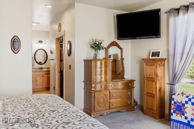 bedroom featuring ensuite bath and light carpet