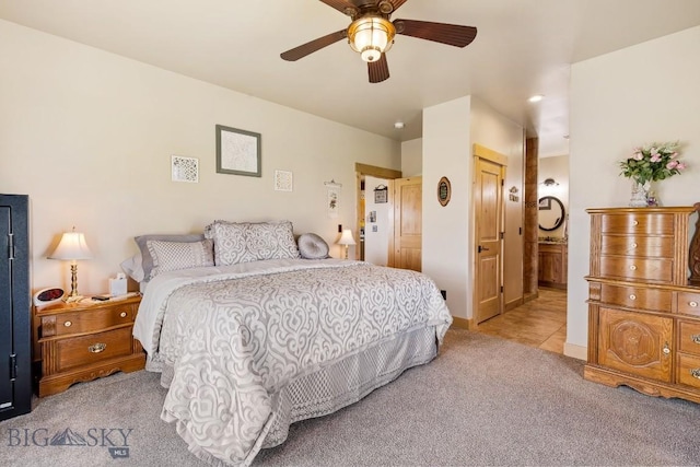 carpeted bedroom featuring baseboards, ceiling fan, and ensuite bath
